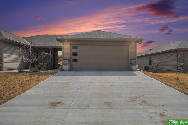 view of front of house with driveway, central AC unit, roof with shingles, and an attached garage