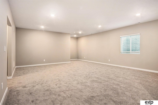 empty room featuring recessed lighting, baseboards, and carpet