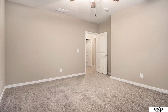 unfurnished room with light colored carpet, ceiling fan, visible vents, and baseboards