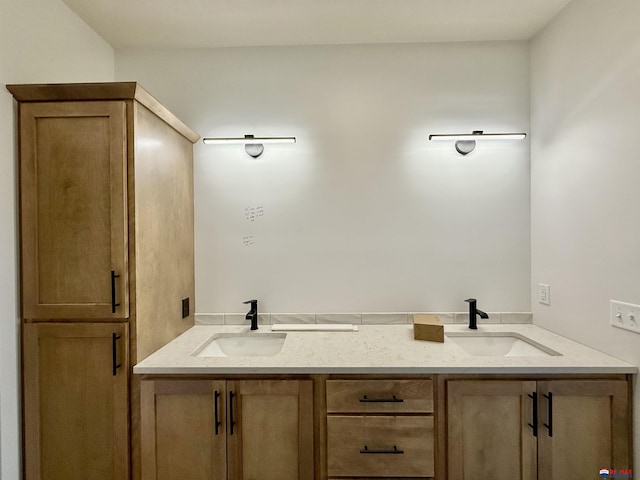 full bathroom with double vanity and a sink