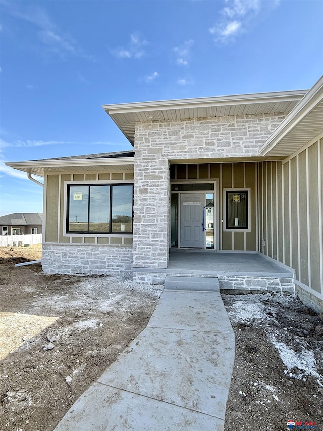 entrance to property with stone siding and covered porch