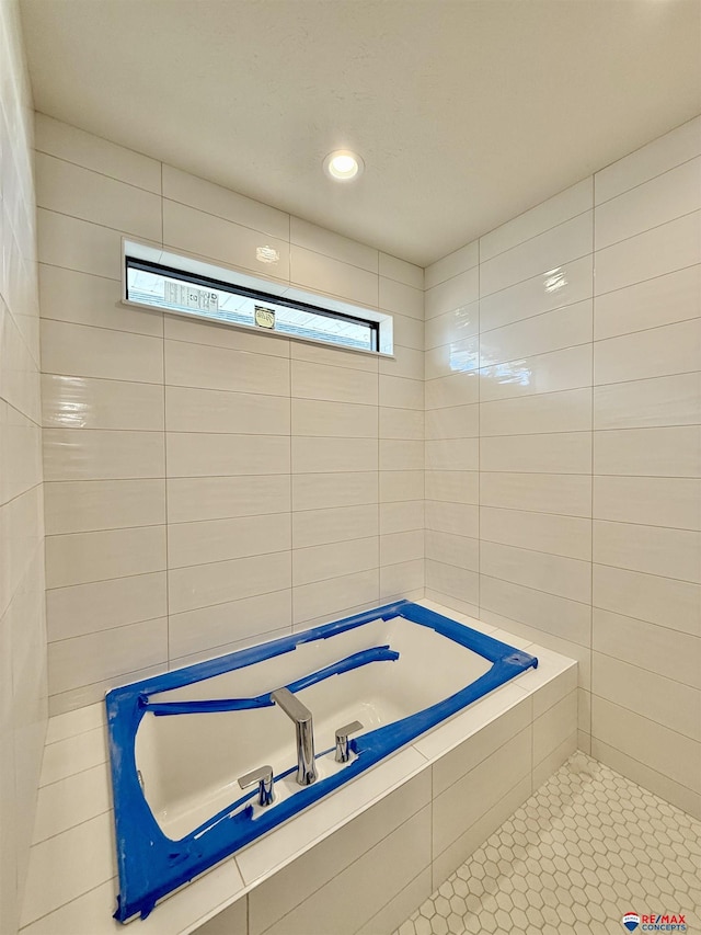 full bath featuring recessed lighting, a garden tub, and tile walls