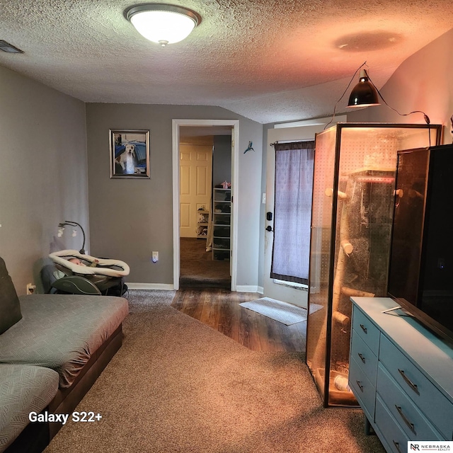 interior space with baseboards, visible vents, dark wood finished floors, a textured ceiling, and dark carpet