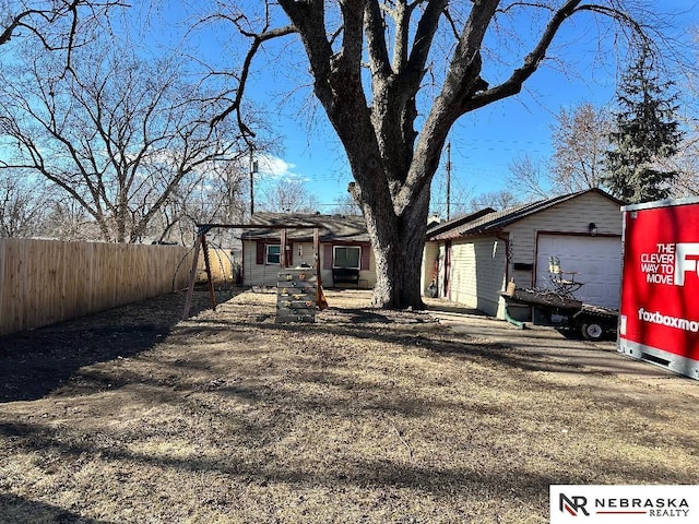 ranch-style home with a garage, an outbuilding, and fence