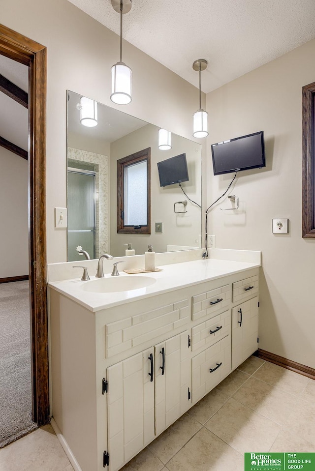 full bath with a textured ceiling, tile patterned flooring, vanity, baseboards, and an enclosed shower