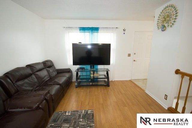 living area featuring baseboards and wood finished floors