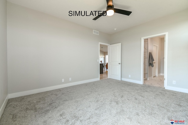 unfurnished bedroom with ensuite bathroom, a ceiling fan, visible vents, baseboards, and carpet