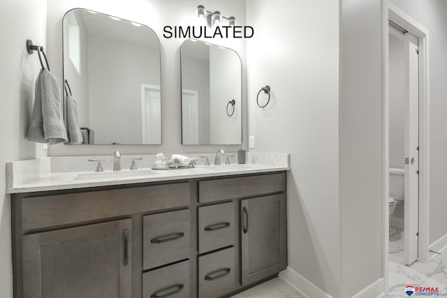 bathroom featuring double vanity, marble finish floor, baseboards, and a sink