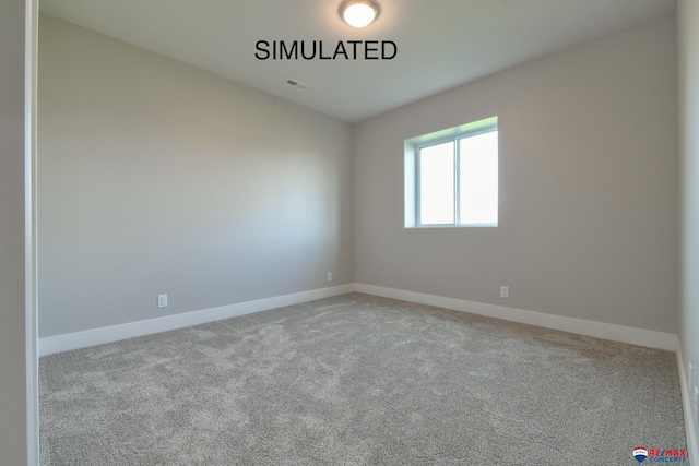 unfurnished room with carpet, visible vents, and baseboards