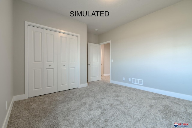 unfurnished bedroom featuring carpet floors, a closet, visible vents, and baseboards