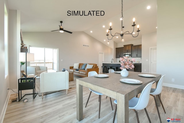 dining room with high vaulted ceiling, ceiling fan with notable chandelier, visible vents, baseboards, and light wood-type flooring