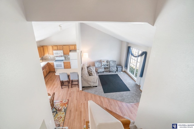 living room with light wood-style floors and vaulted ceiling