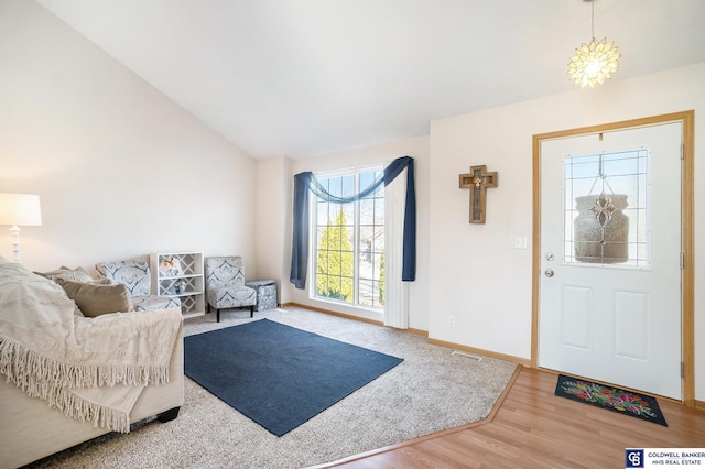 entrance foyer with baseboards, lofted ceiling, and wood finished floors