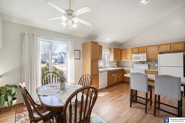 kitchen with a sink, white appliances, light countertops, and ceiling fan