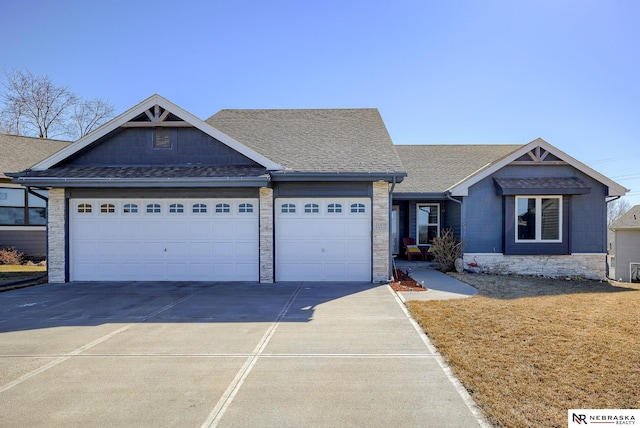 view of front of house with an attached garage, driveway, and a shingled roof