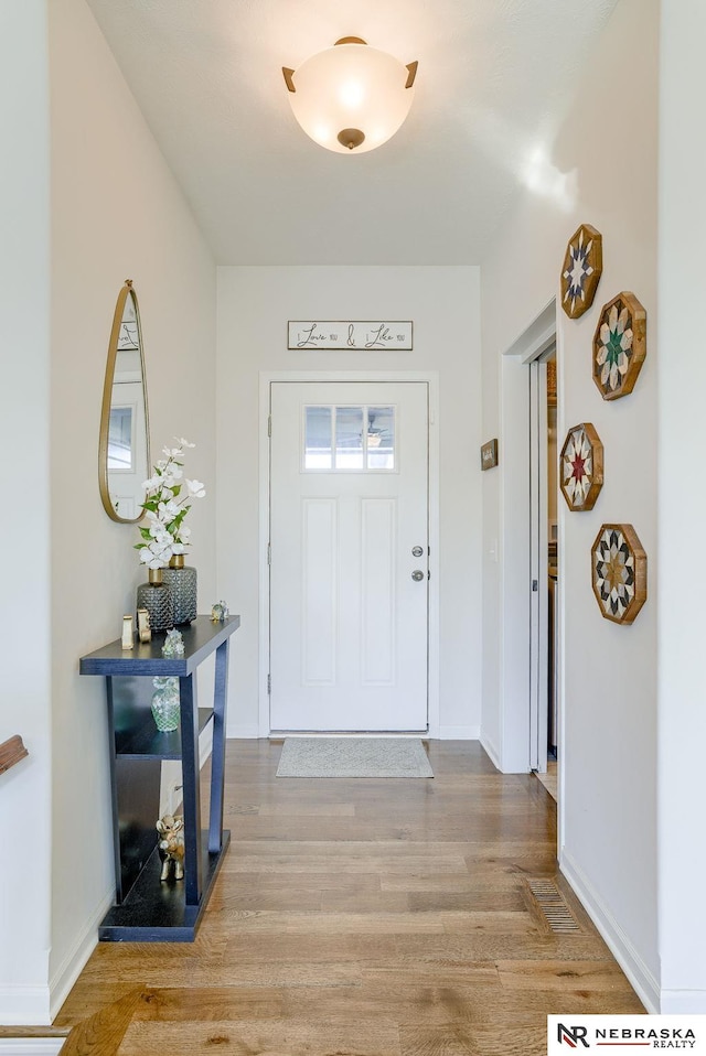 entrance foyer featuring light wood-type flooring and baseboards