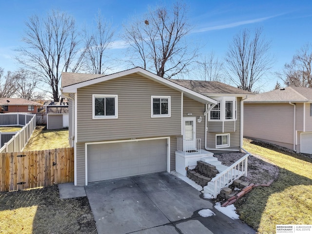 bi-level home featuring roof with shingles and fence