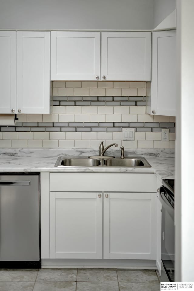 kitchen featuring dishwasher, decorative backsplash, stove, white cabinetry, and a sink