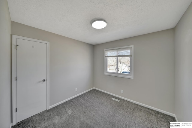 empty room featuring visible vents, baseboards, carpet, and a textured ceiling