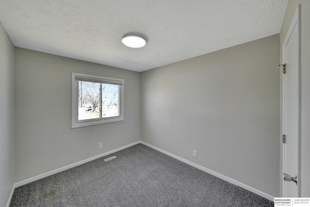 carpeted spare room with visible vents, baseboards, and a textured ceiling