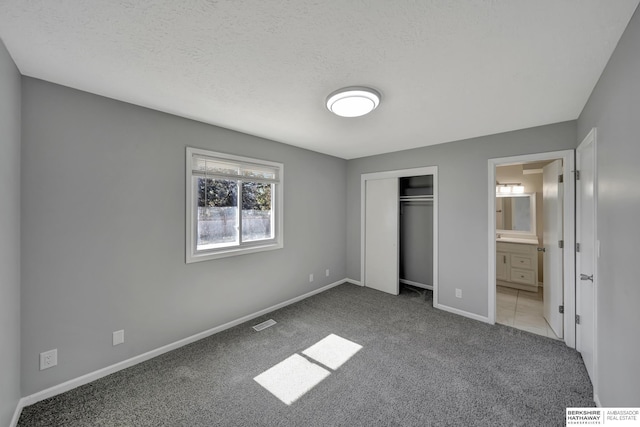 unfurnished bedroom with baseboards, visible vents, a closet, a textured ceiling, and carpet flooring