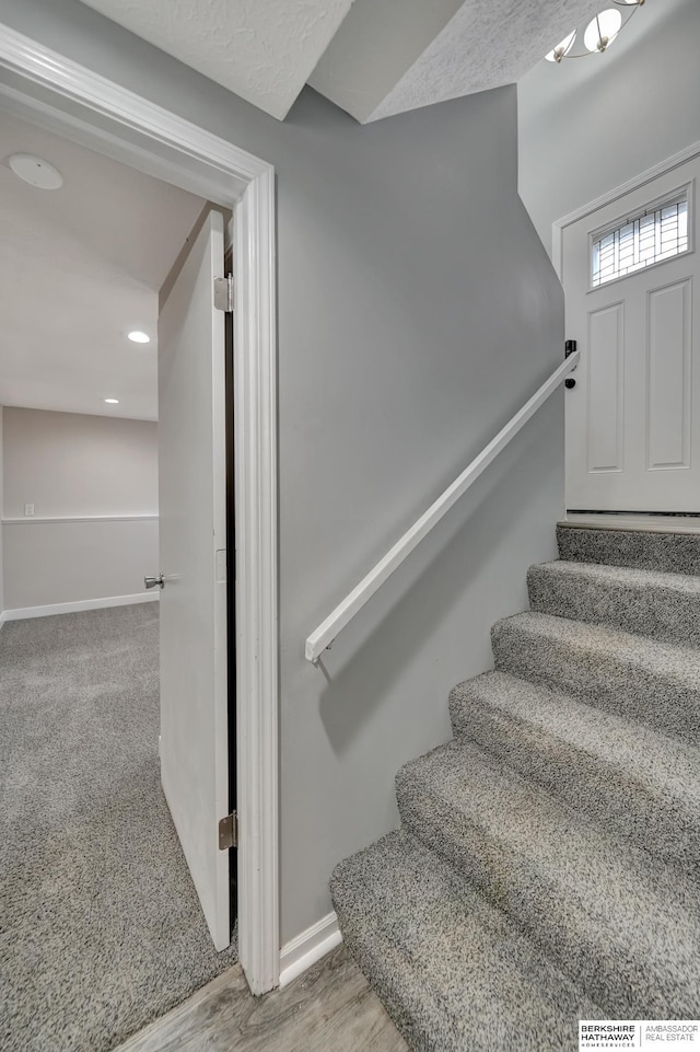 staircase featuring baseboards and wood finished floors