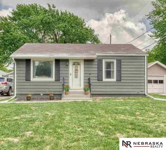 view of front of property featuring a front lawn, a garage, and an outdoor structure