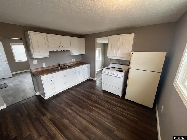 kitchen featuring white appliances, a sink, white cabinetry, and a healthy amount of sunlight