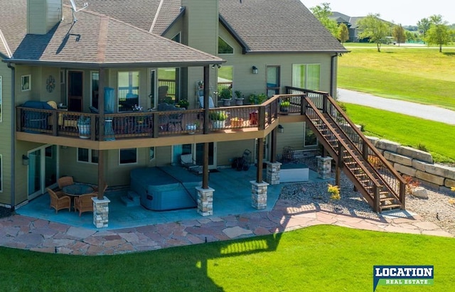 back of property with a shingled roof, a patio area, a yard, and a chimney