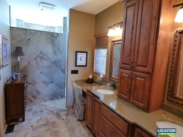 bathroom with double vanity, a walk in shower, and a sink