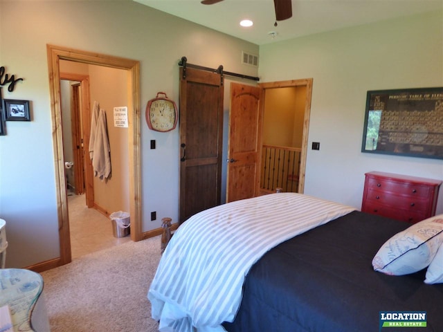 bedroom with light carpet, a barn door, visible vents, baseboards, and recessed lighting