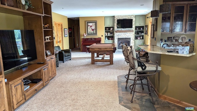 living room featuring a stone fireplace and light colored carpet