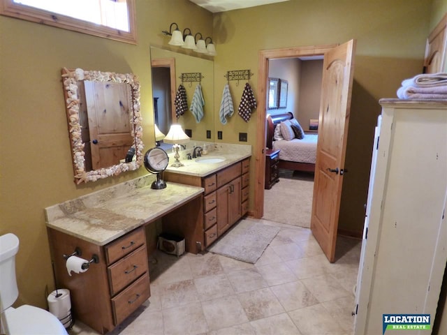 bathroom with toilet, ensuite bath, plenty of natural light, and vanity