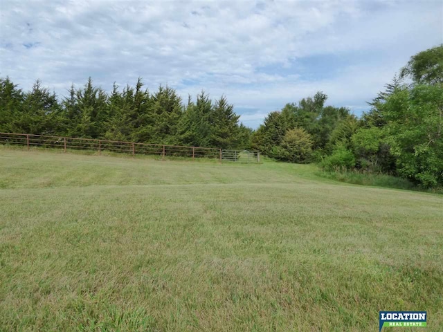 view of yard featuring a rural view and fence