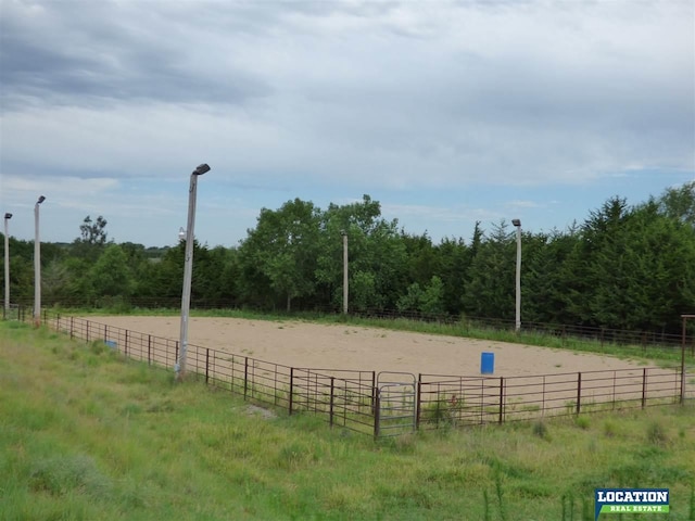 view of property's community featuring an enclosed area, a rural view, and a wooded view