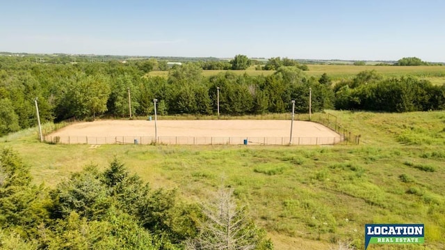 view of community featuring an enclosed area, fence, and a rural view