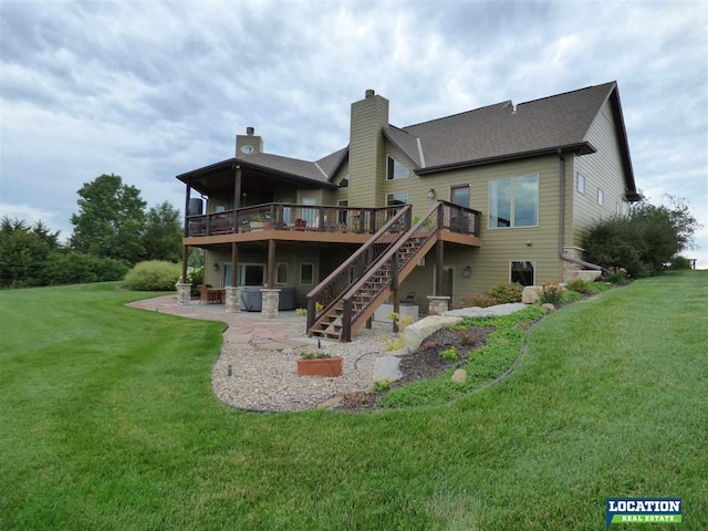 rear view of property featuring a chimney, a lawn, stairway, a patio area, and a wooden deck