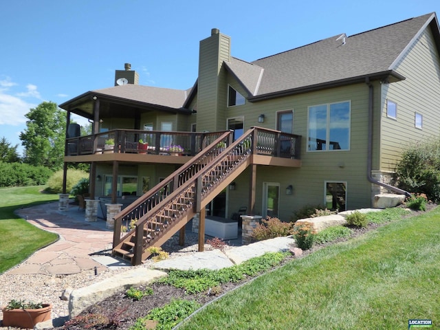 back of house featuring a deck, a patio, stairway, a lawn, and a chimney