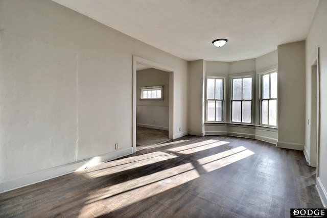 empty room with visible vents, baseboards, and wood finished floors