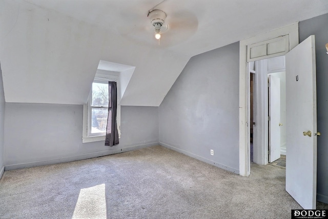 additional living space featuring vaulted ceiling, carpet, a ceiling fan, and baseboards