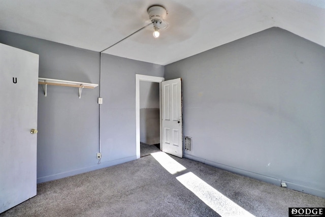 unfurnished bedroom featuring a ceiling fan, visible vents, vaulted ceiling, and carpet flooring