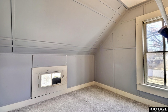 additional living space featuring lofted ceiling and carpet flooring