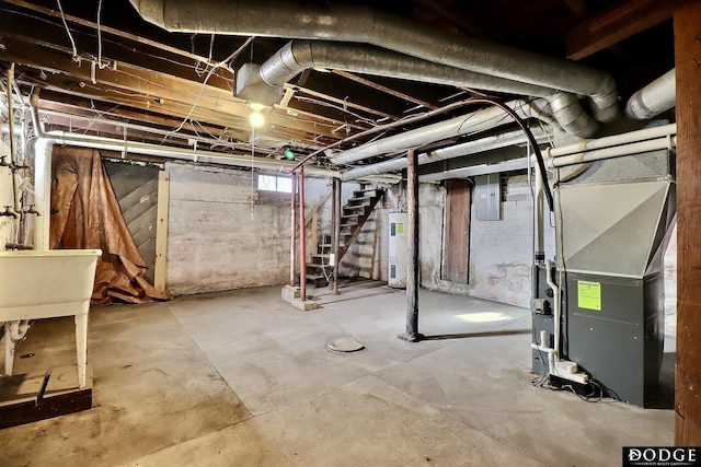 basement featuring heating unit, stairway, electric water heater, a sink, and electric panel