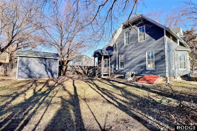 exterior space featuring a shed, fence, and an outbuilding