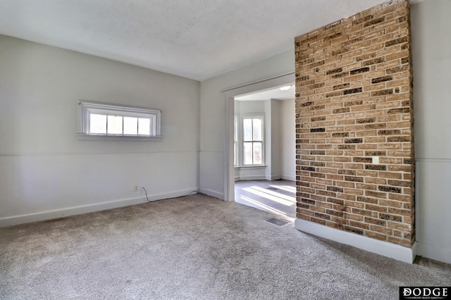 carpeted spare room with visible vents and baseboards