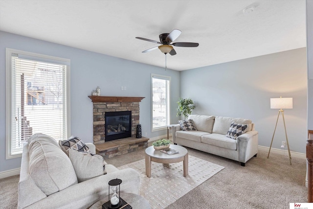 living room featuring ceiling fan, carpet floors, a fireplace, and baseboards