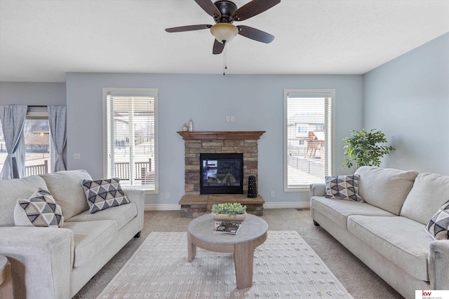 living room with baseboards, a fireplace, and light colored carpet