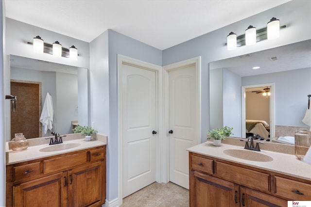 ensuite bathroom featuring two vanities, a sink, and ensuite bath