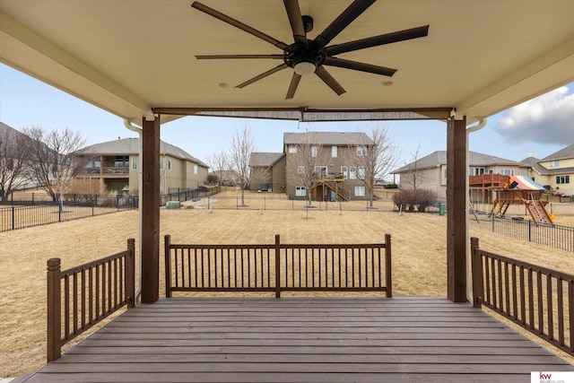 deck with a ceiling fan, a residential view, a playground, and fence