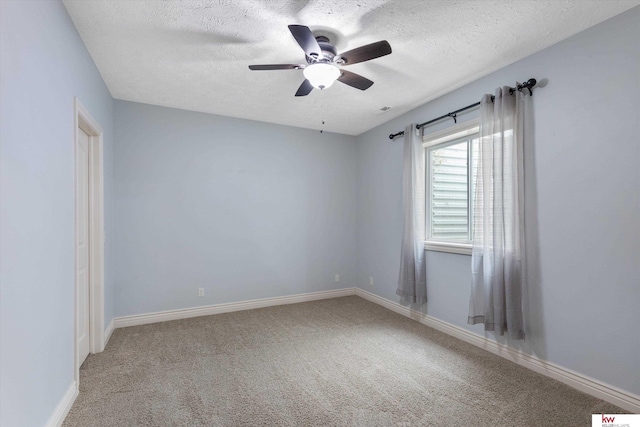 spare room featuring a textured ceiling, carpet floors, and baseboards